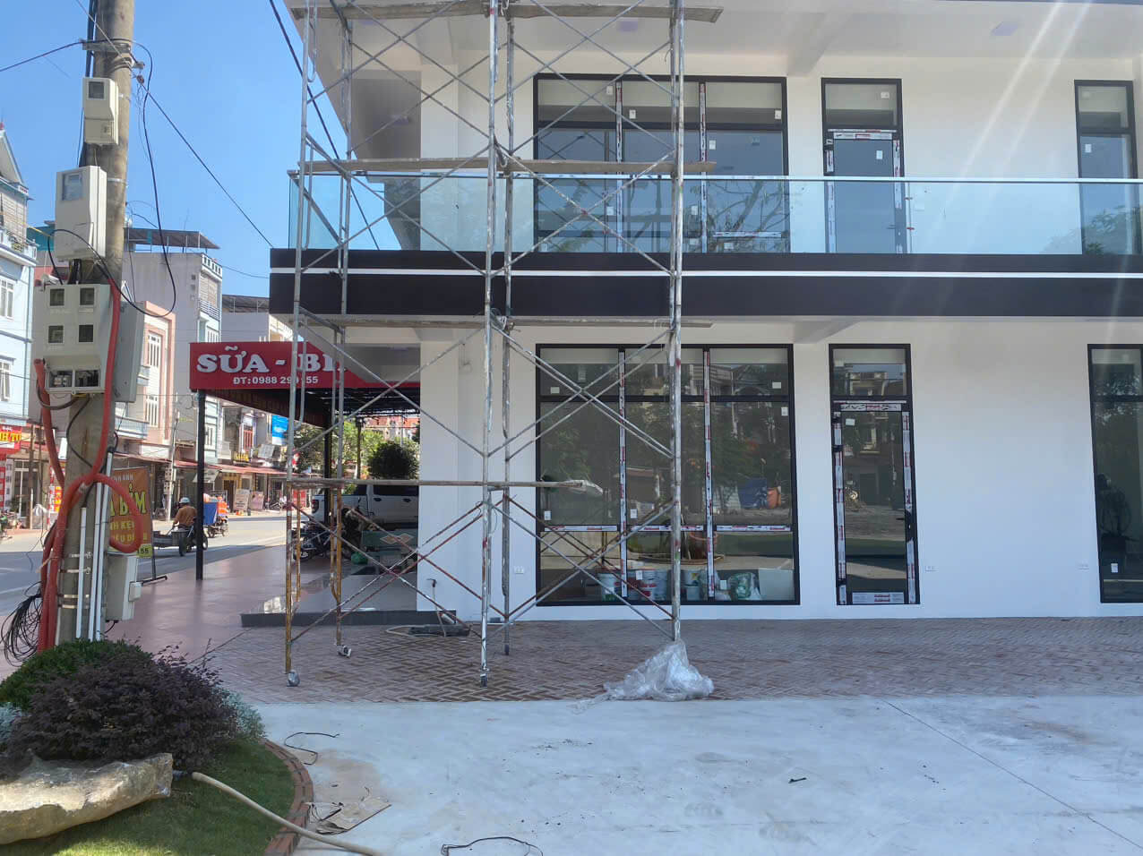 Giàn giáo lắp đặt trước mặt tiền nhà phố đang thi công với cửa kính khung nhôm hiện đại